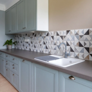 Modern kitchen splashback tiles with geometric patterns behind a sink in a contemporary UK kitchen design