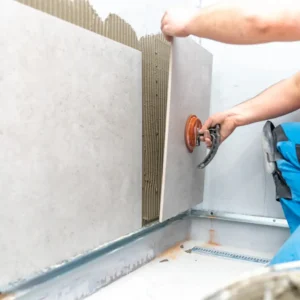 Installing large porcelain wall tiles with adhesive in a shower area during a UK bathroom renovation